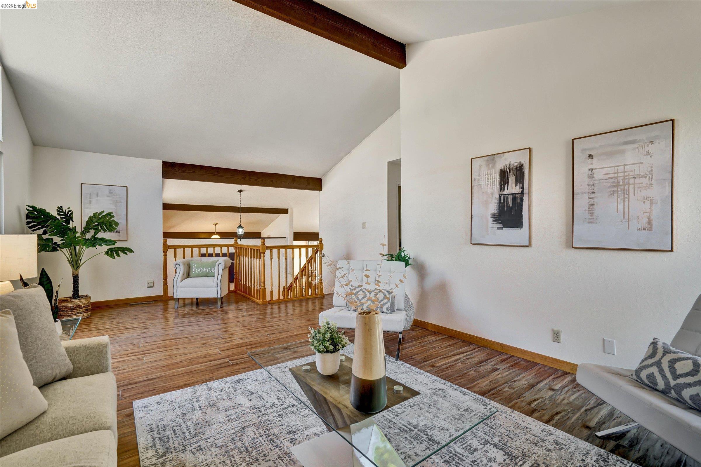 2826 Wright Avenue Pinole, CA 94564 - Photo 37 of 70 Living area featuring vaulted ceilings with exposed beams, wood-finish flooring, and an open concept balcony with natural wood railing