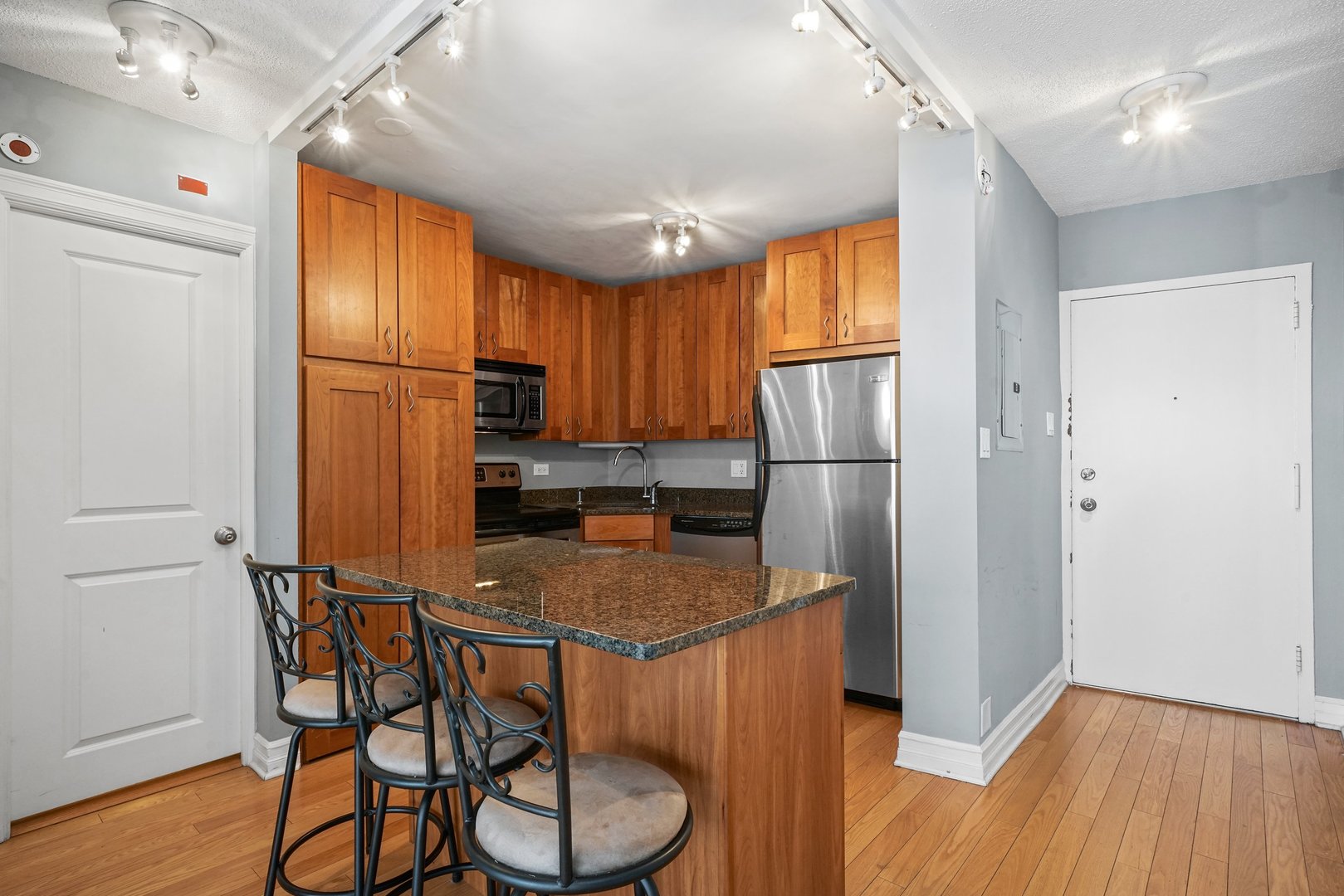2930 North Sheridan Road, Unit 805 Chicago, IL 60657 - Photo 6 of 21 a kitchen with stainless steel appliances granite countertop a refrigerator a stove a sink dishwasher and a refrigerator with wooden floor