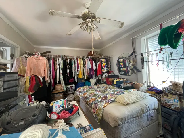 a bed room with a bed a couch and a flat tv screen