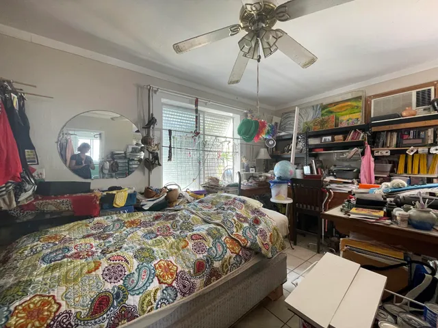 a bedroom with a bed a flat screen tv and a chandelier