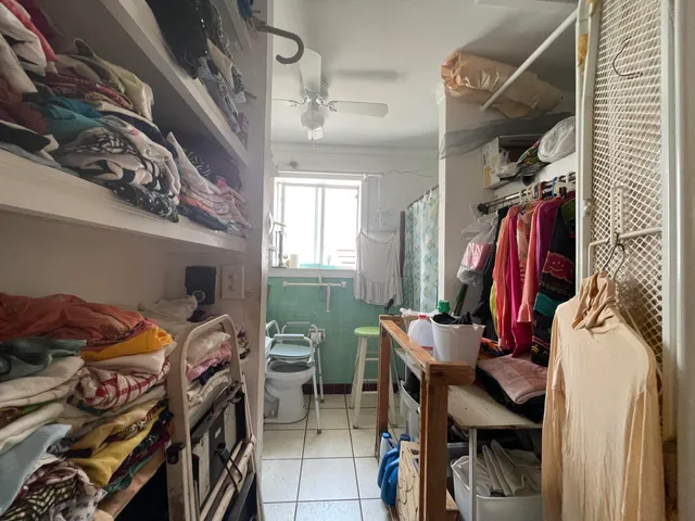 a view of walk in closet with clothes