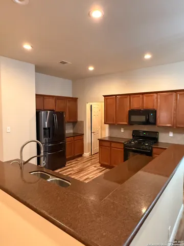 a kitchen with stainless steel appliances granite countertop a sink refrigerator and microwave