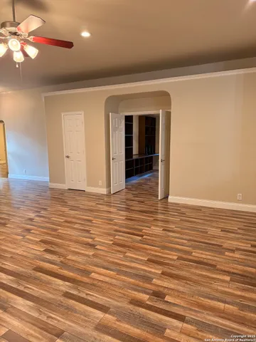 en empty room with wooden floor and windows