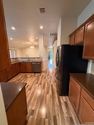 a open kitchen with stainless steel appliances granite countertop a refrigerator and a sink