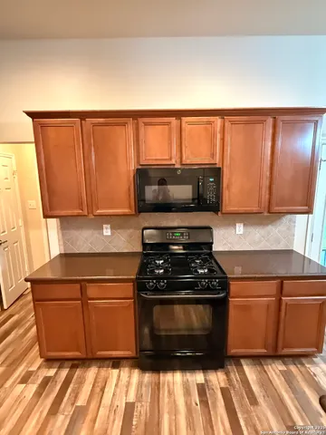 a kitchen with wooden cabinets and a stove top oven