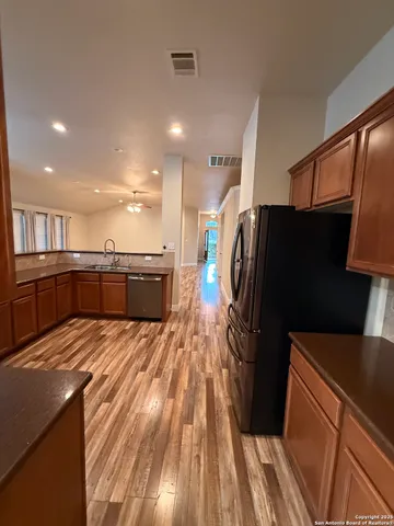 a large kitchen with a sink and refrigerator