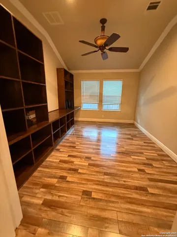 a view of a room with wooden floor and a ceiling fan