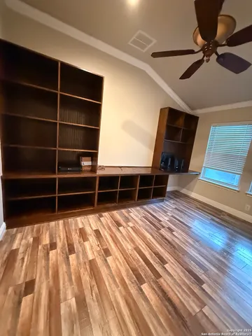 a view of empty room with wooden floor and windows
