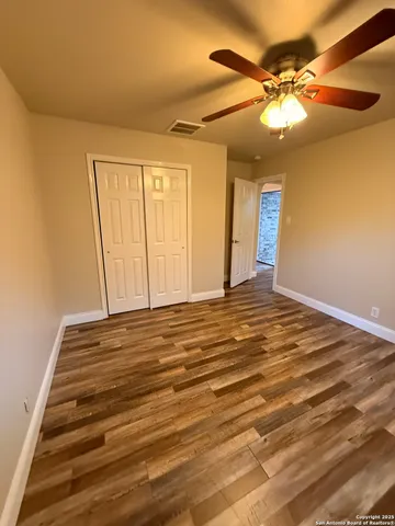 a view of a room with wooden floor and fan