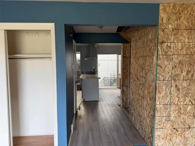 a view of a hallway with wooden floor and a bathroom
