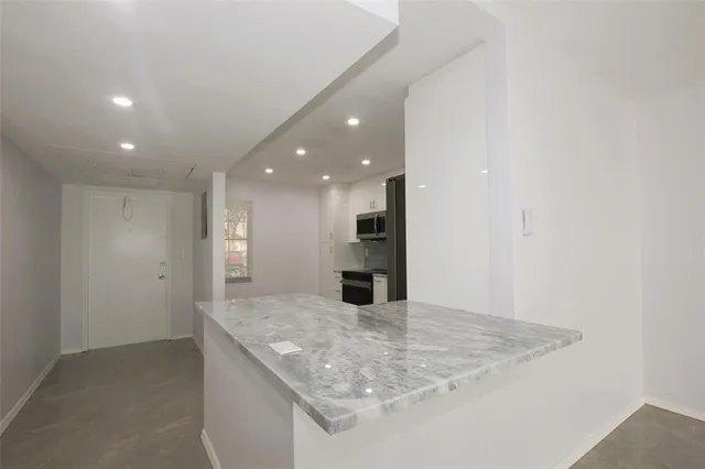 an empty room with a kitchen and a sink