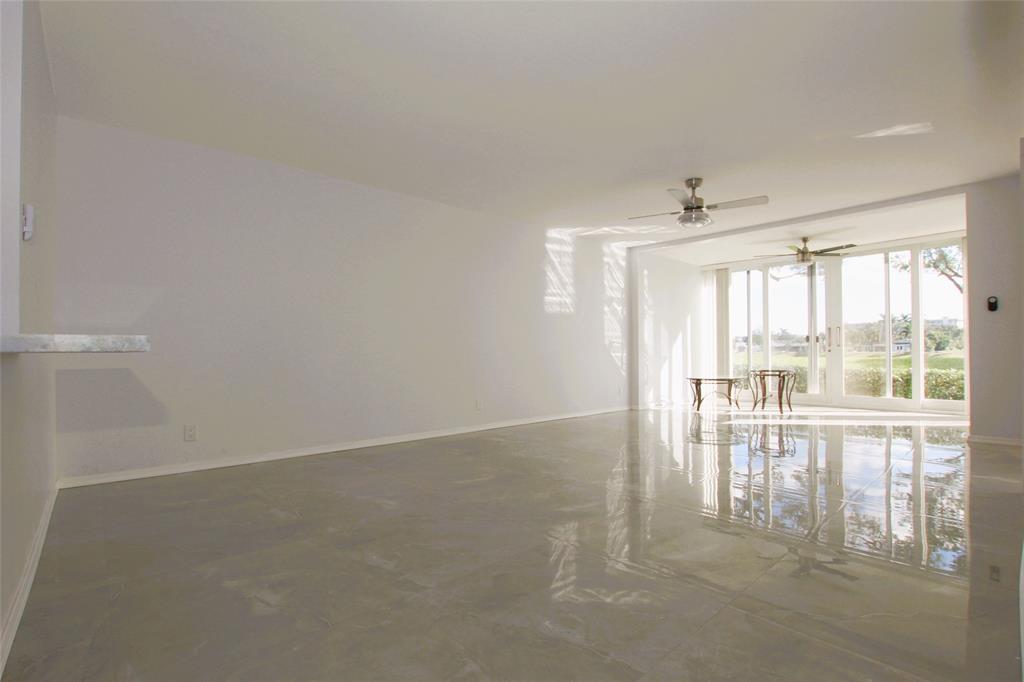 3100 North Course Lane, Unit 103 Pompano Beach, FL 33069 - Photo 19 of 51 a view of empty room with wooden floor and fan