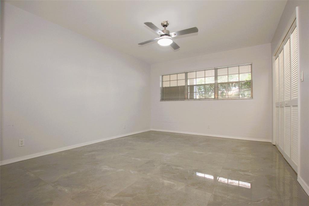 3100 North Course Lane, Unit 103 Pompano Beach, FL 33069 - Photo 34 of 51 an empty room with windows and fan