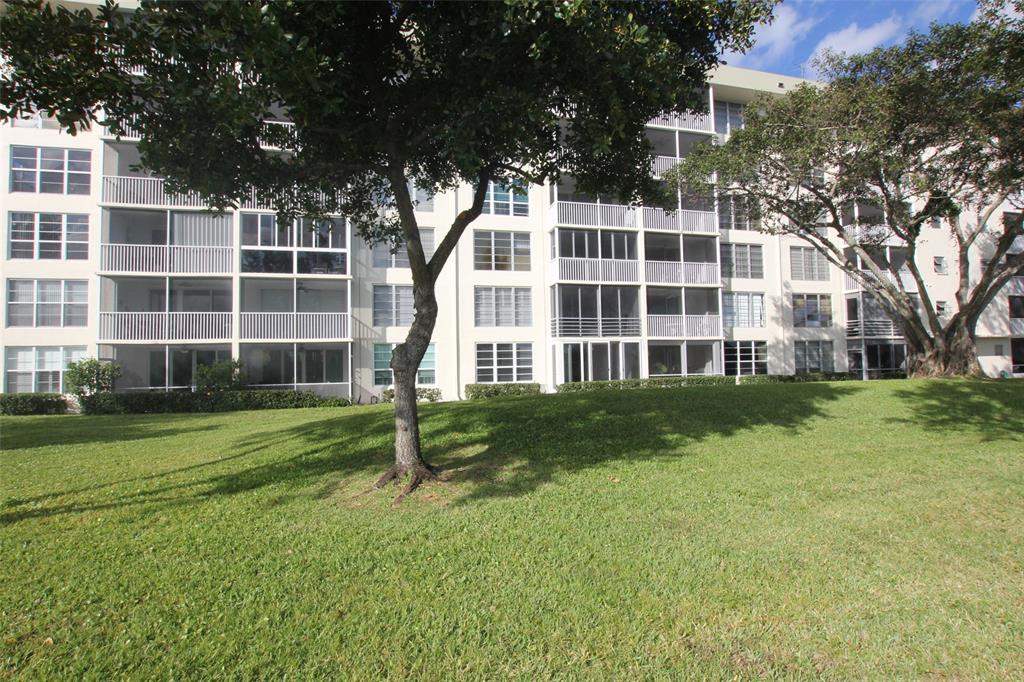 3100 North Course Lane, Unit 103 Pompano Beach, FL 33069 - Photo 47 of 51 a front view of a building with a yard