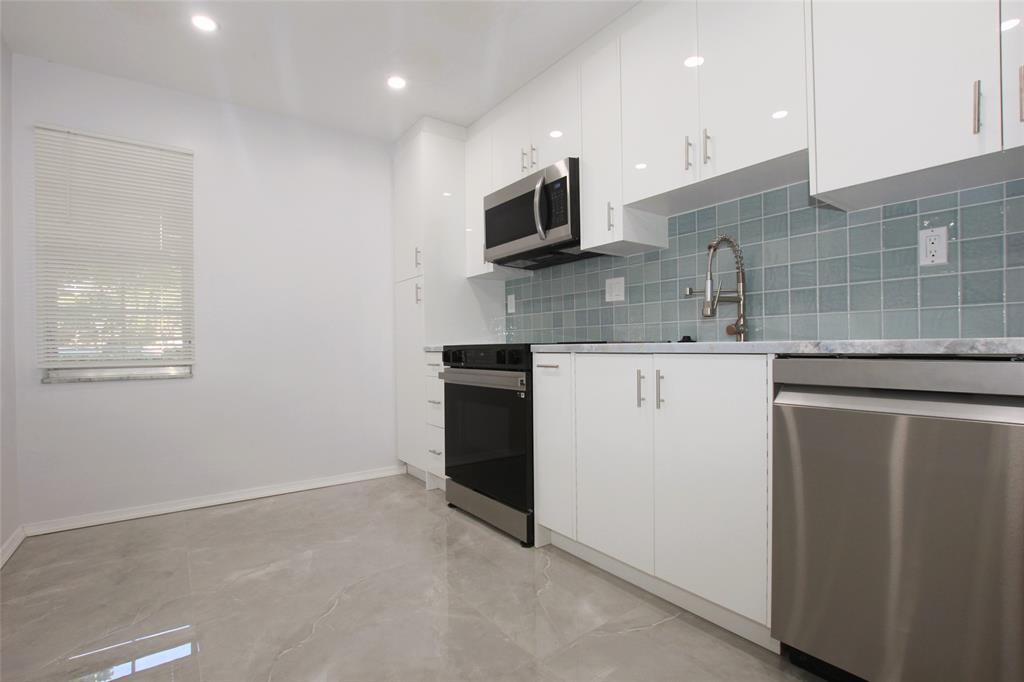 3100 North Course Lane, Unit 103 Pompano Beach, FL 33069 - Photo 5 of 51 a kitchen with stainless steel appliances granite countertop a sink and a microwave