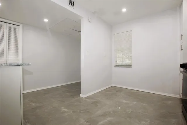 a large kitchen with stainless steel appliances kitchen island granite countertop a refrigerator and a sink