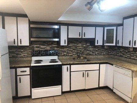 84 Thorndike Street, Unit B Cambridge, MA 02141 - Photo 1 of 8 a kitchen with granite countertop white cabinets and white appliances