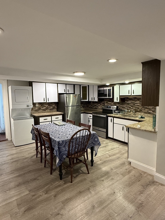 84 Thorndike Street, Unit B Cambridge, MA 02141 - Photo 2 of 8 a large kitchen with kitchen island a stove a sink a dining table and chairs
