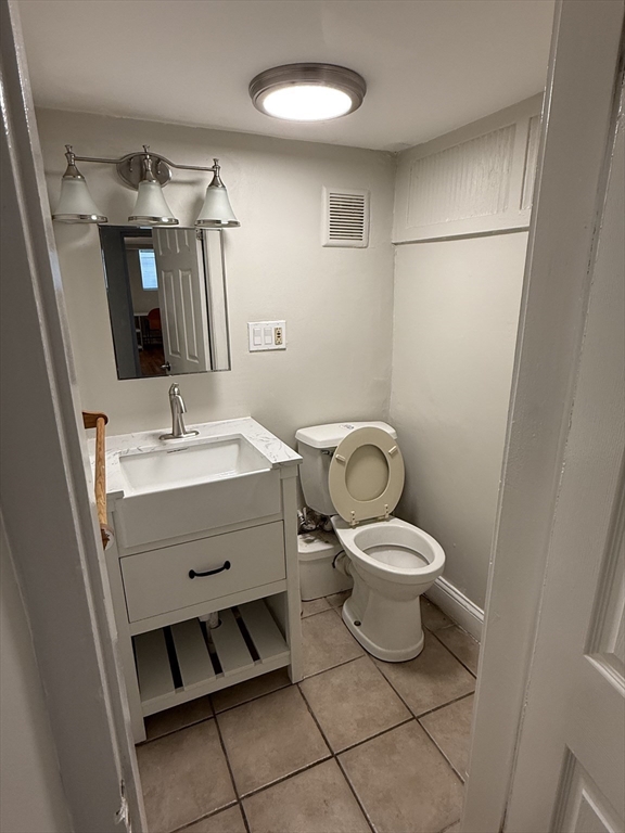 84 Thorndike Street, Unit B Cambridge, MA 02141 - Photo 8 of 8 a bathroom with a toilet sink and mirror