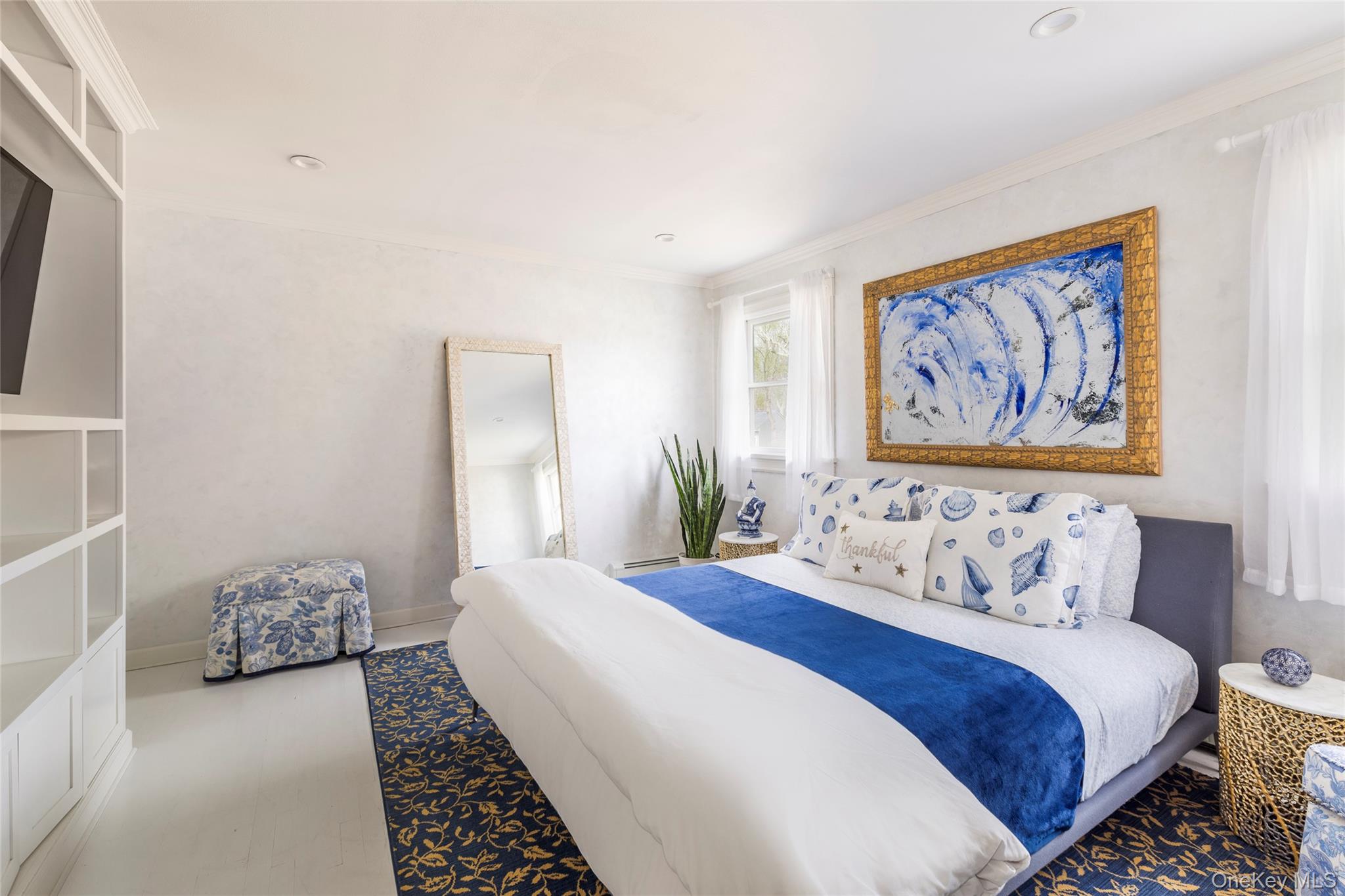 8 Westerly Court Hampton Bays, NY 11946 - Photo 14 of 26 a bedroom with a bed and a painting on the wall