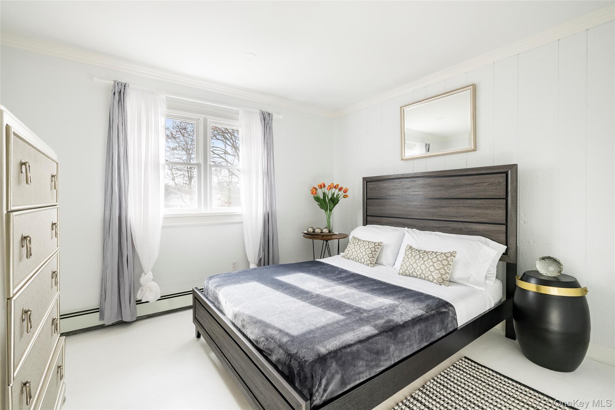 8 Westerly Court Hampton Bays, NY 11946 - Photo 17 of 26 a bedroom with a bed and window