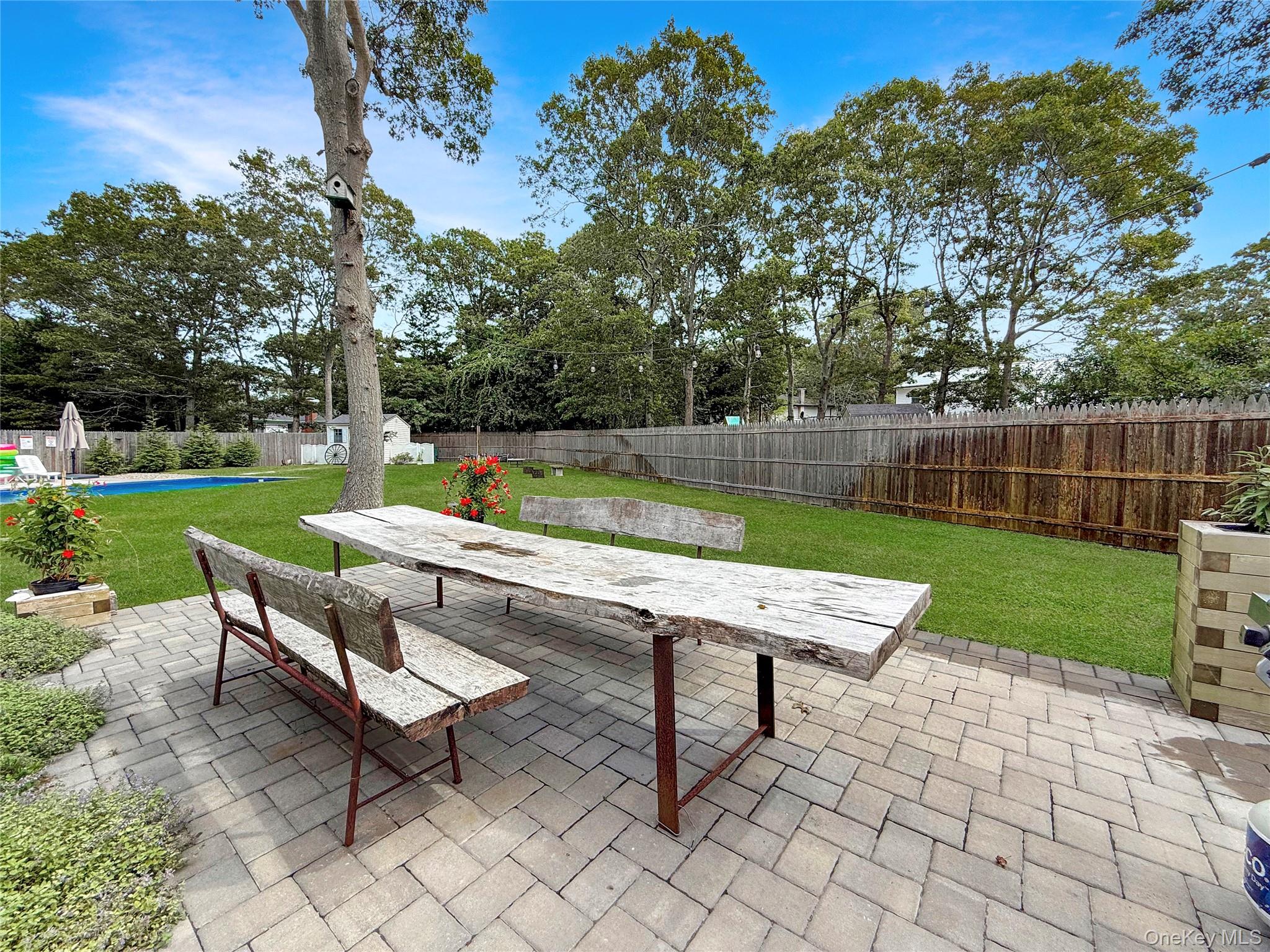 8 Westerly Court Hampton Bays, NY 11946 - Photo 3 of 26 an outdoor sitting area with a table and a chairs