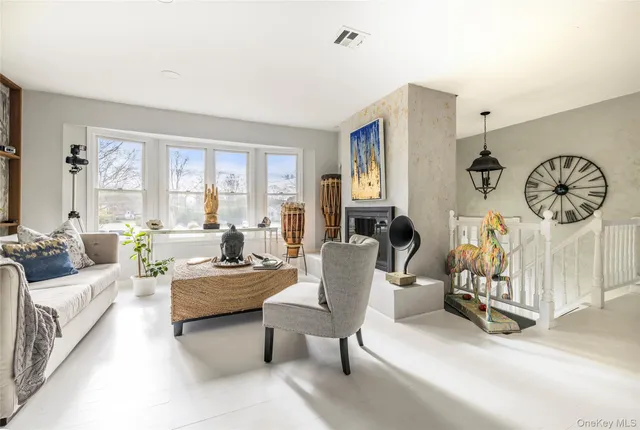 a living room with furniture a flat screen tv and a large window