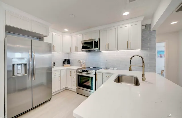 a kitchen that has a sink and a stove in it