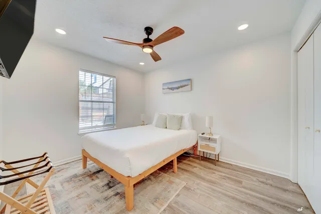 a bedroom with a bed and a ceiling fan