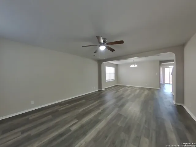 a view of an empty room and window and wooden floor