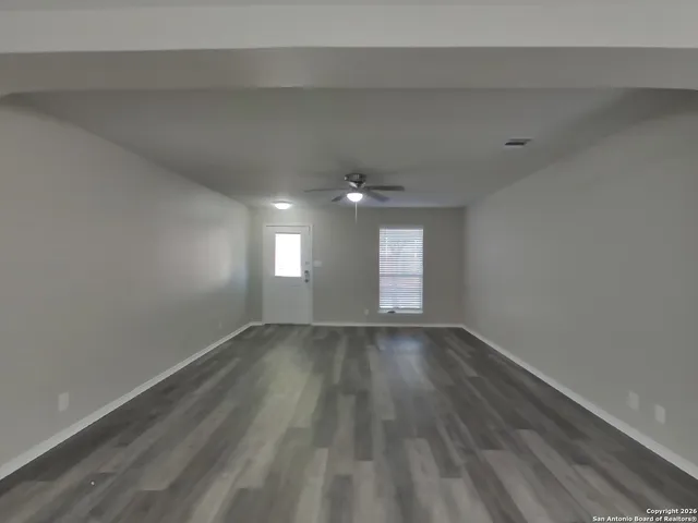 wooden floor in an empty room with a window