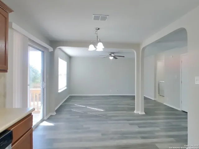 a view of an empty room with glass door and a window