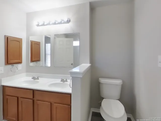 a bathroom with a toilet sink and mirror