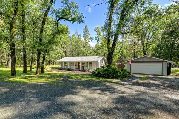 a front view of a house with a yard and trees