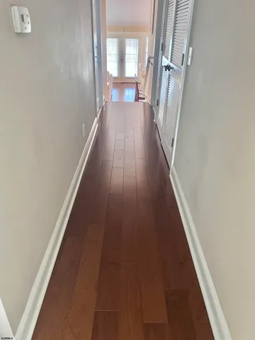 a view of a hallway with wooden floor