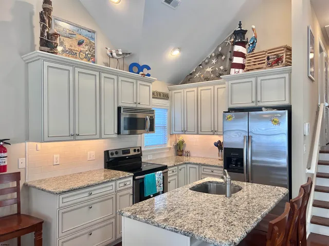 a kitchen with stainless steel appliances granite countertop a sink refrigerator and microwave