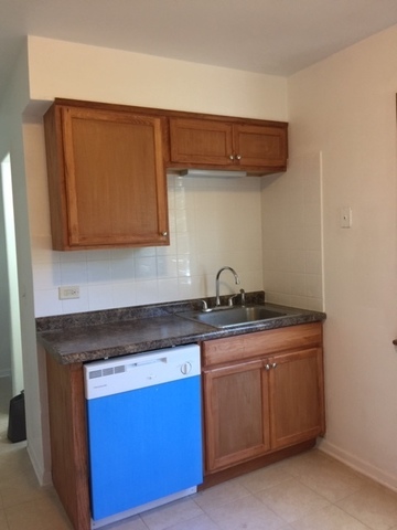 10071 Frontage Road, Unit G Skokie, IL 60077 - Photo 11 of 22 a kitchen with stainless steel appliances granite countertop a sink a stove and a microwave