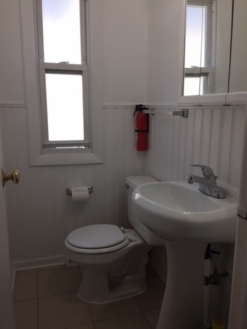 10071 Frontage Road, Unit G Skokie, IL 60077 - Photo 13 of 22 a white toilet sitting next to a bathroom sink