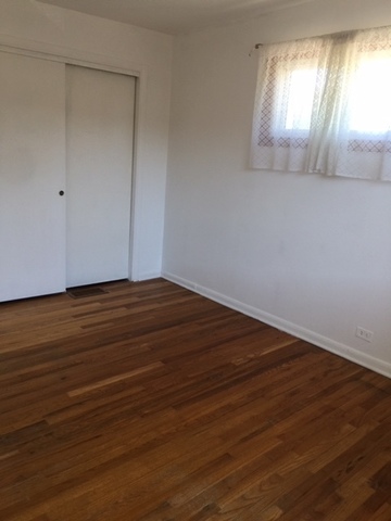 10071 Frontage Road, Unit G Skokie, IL 60077 - Photo 7 of 22 an empty room with wooden floor and windows
