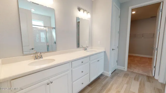 a bathroom with double vanity sink and a mirror
