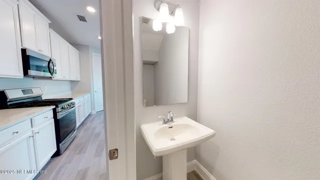 a kitchen with a sink dishwasher and a stove with wooden floor