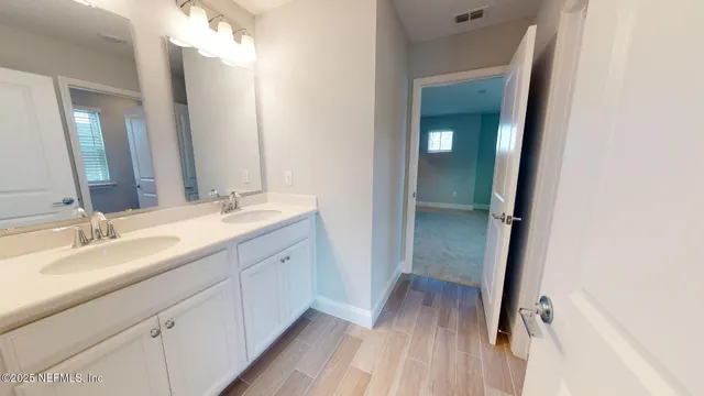 a bathroom with a double vanity sink and mirror with shower