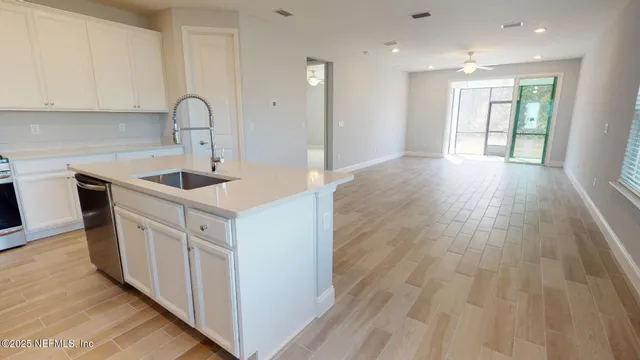 a kitchen with kitchen island white cabinets and a sink
