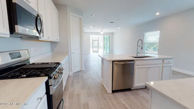 a kitchen with stainless steel appliances granite countertop a stove a sink and a microwave