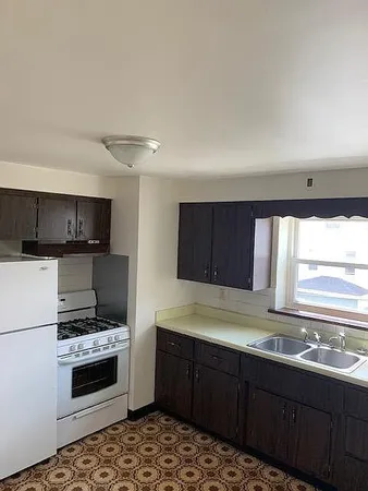 a kitchen with kitchen island granite countertop a sink cabinets and stainless steel appliances