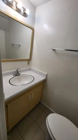 a bathroom with a sink a toilet and mirror