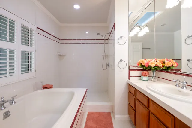 a bathroom with a tub sink and mirror
