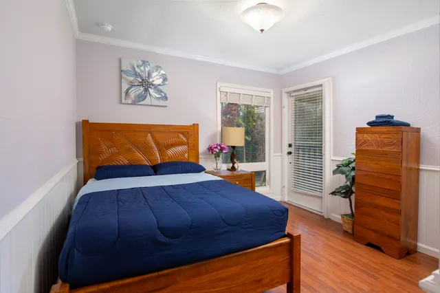 a bedroom with a bed and wooden floor