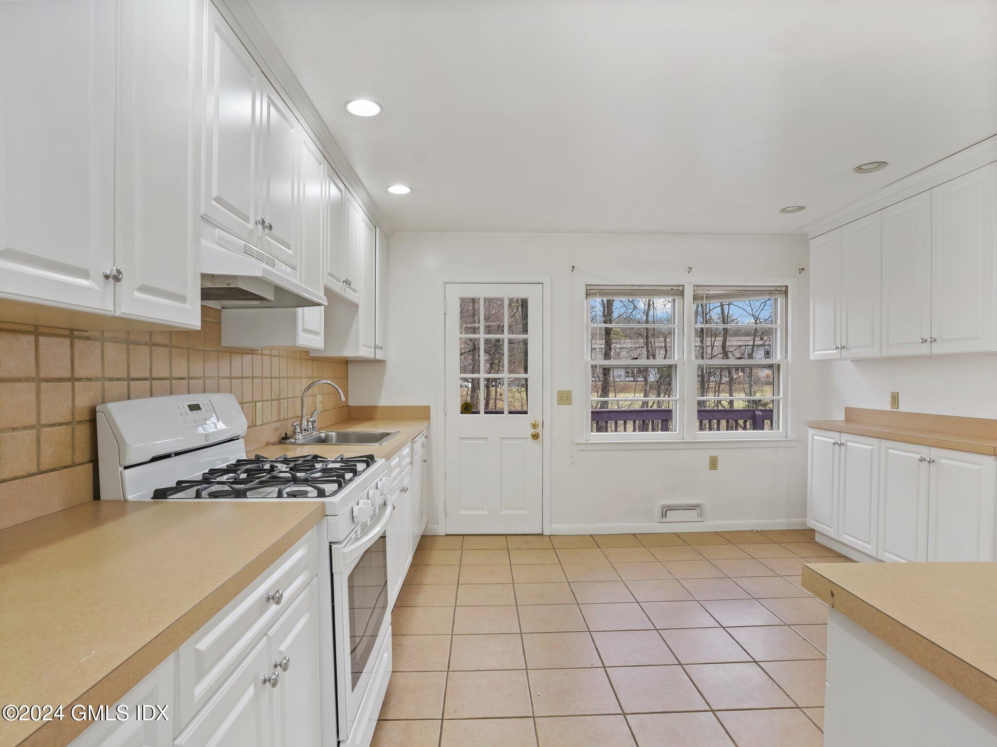 59 Lancer Road Riverside, CT 06878 - Photo 7 of 13 a kitchen with a stove a sink and a refrigerator