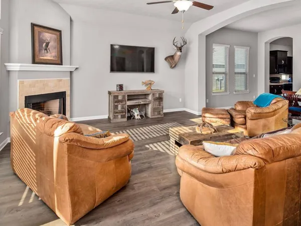 a living room with furniture a flat screen tv and a fireplace